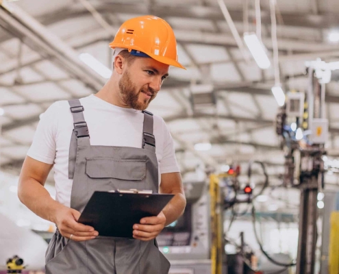 Workman at store house in orange helmet